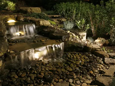 Stone waterfall and stream lit from within so the moving water glows