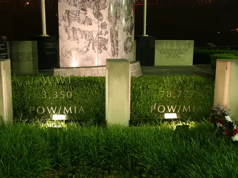 POW MIA memorial stones lit from ground level with engraved numerals legible